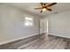 Spacious bedroom with ceiling fan, window, and light gray walls over new plank flooring at 7034 Southwind Dr, Hudson, FL 34667