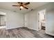 This bedroom features wood flooring, a ceiling fan, and an ensuite bathroom with a white vanity at 7034 Southwind Dr, Hudson, FL 34667