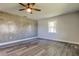 This bedroom has gray waterproof floors, a ceiling fan, a new window, and a decorative wall at 7034 Southwind Dr, Hudson, FL 34667