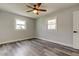 This bedroom has gray wood flooring, a ceiling fan, and plenty of natural light from two windows at 7034 Southwind Dr, Hudson, FL 34667