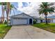 Charming single-story home featuring a two-car garage, stone accents, and well-maintained landscaping at 7034 Southwind Dr, Hudson, FL 34667