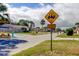 Street view with a golf cart crossing sign, reflecting a golf-friendly community at 7034 Southwind Dr, Hudson, FL 34667