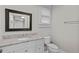 Bathroom features a granite vanity top with a framed mirror and natural light from the window at 709 W Azeele St, Tampa, FL 33606