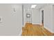 Hallway with hardwood flooring and white trim leads to a bright bathroom with modern finishes at 709 W Azeele St, Tampa, FL 33606
