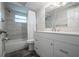 Bathroom with a tub, tile surround, new vanity, and wood-look tile flooring at 7144 Fairfax Dr, Port Richey, FL 34668