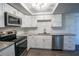 Modern kitchen featuring stainless steel appliances, granite countertops, and white shaker style cabinets at 7144 Fairfax Dr, Port Richey, FL 34668