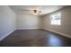 Spacious living room has a ceiling fan, window, and attractive wood-look flooring at 7144 Fairfax Dr, Port Richey, FL 34668