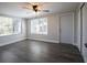 Bright living room with a ceiling fan, windows with blinds, and wood-look flooring at 7144 Fairfax Dr, Port Richey, FL 34668