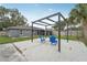 Relaxing backyard patio area featuring chairs and a fire pit under an attractive wooden pergola at 7402 Sherren Dr, Tampa, FL 33619