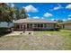 Rear view of the home, featuring a patio and well-manicured shrubbery at 8045 Sugarbush Dr, Spring Hill, FL 34606