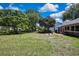 Spacious backyard with lush greenery, mature trees, and a private patio at 8045 Sugarbush Dr, Spring Hill, FL 34606
