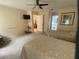 Bright bedroom featuring neutral tones, two twin beds, a ceiling fan, and an en-suite bathroom at 8045 Sugarbush Dr, Spring Hill, FL 34606