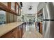 Modern kitchen with stainless steel appliances, wooden cabinets, and open to the dining area at 8045 Sugarbush Dr, Spring Hill, FL 34606