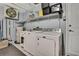 Functional laundry room area with washer, dryer, storage shelf, and utility sink at 8045 Sugarbush Dr, Spring Hill, FL 34606
