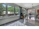 Bright living room with hardwood floors, large windows, and views to the outside yard and garden at 8045 Sugarbush Dr, Spring Hill, FL 34606