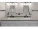 Bathroom featuring a dual sink vanity with granite countertops, framed mirrors, and black hardware at 951 9Th S Ave, St Petersburg, FL 33705
