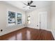 An empty bedroom with hardwood floors, a ceiling fan, large windows, and white trim at 951 9Th S Ave, St Petersburg, FL 33705