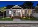 Charming single-Gathering home with a manicured lawn, brick steps, inviting front porch illuminated at twilight at 951 9Th S Ave, St Petersburg, FL 33705