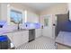 Updated kitchen with stainless steel appliances, white cabinets, granite countertops, and black and white tile flooring at 951 9Th S Ave, St Petersburg, FL 33705