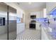 Modern kitchen with white cabinets, stainless steel appliances, and stylish black and white patterned flooring at 951 9Th S Ave, St Petersburg, FL 33705