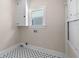 Well-lit laundry room with tiled floor, a window, and storage for convenience at 951 9Th S Ave, St Petersburg, FL 33705