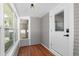 Cozy sunroom entrance featuring wood floors, gray paneled walls, and a digital door lock at 951 9Th S Ave, St Petersburg, FL 33705