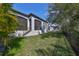 Exterior view of a home with a well-maintained lawn, screened lanai, and privacy fence at 1009 Seagrape Dr, Ruskin, FL 33570