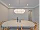 Minimalist dining room featuring modern light fixture and wood-framed chairs at 1009 Seagrape Dr, Ruskin, FL 33570