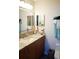 Bathroom vanity featuring a large mirror, granite countertops and wooden cabinets at 104 Gloucester Blvd # 340, Sun City Center, FL 33573
