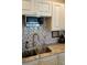 Kitchen sink with stainless steel faucet, granite countertops, tile backsplash and microwave at 104 Gloucester Blvd # 340, Sun City Center, FL 33573