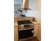 Close up of a kitchen featuring granite countertops and stainless steel stove with modern vent hood at 104 Gloucester Blvd # 340, Sun City Center, FL 33573