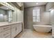 Stylish bathroom boasts a modern vanity, sleek fixtures, a luxurious soaking tub, and shower at 10614 Chambers Dr, Tampa, FL 33626