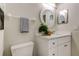 Elegant bathroom featuring a white vanity, round mirror, and decor, illuminated by modern lighting at 10614 Chambers Dr, Tampa, FL 33626