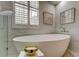 Close-up of an oval freestanding tub, marble wall, and decor adding to the luxurious bathroom ambiance at 10614 Chambers Dr, Tampa, FL 33626