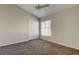 Cozy bedroom with plush carpeting, a ceiling fan, and a closet for storage at 10614 Chambers Dr, Tampa, FL 33626