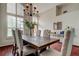 Elegant dining room featuring a large wooden table with tufted chairs and a modern chandelier at 10614 Chambers Dr, Tampa, FL 33626
