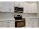 Kitchen features new stainless steel appliances, white cabinets, and modern fixtures at 10614 Chambers Dr, Tampa, FL 33626