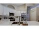 Quartz countertop with stainless steel appliances in a kitchen featuring overhead arches and bright lighting at 10614 Chambers Dr, Tampa, FL 33626