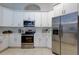 Bright kitchen featuring white cabinets, stainless steel appliances, and ample counter space at 10614 Chambers Dr, Tampa, FL 33626