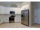 Well-lit kitchen includes stainless steel appliances, white cabinets, and tile flooring at 10614 Chambers Dr, Tampa, FL 33626