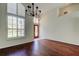 Open-concept living room with hardwood floors, chandelier, and decorative window with privacy shutters at 10614 Chambers Dr, Tampa, FL 33626