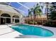 Enclosed pool area with clear water, surrounded by white decking and a screened enclosure at 10614 Chambers Dr, Tampa, FL 33626