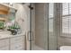 Modern shower featuring marble walls, a glass door, and natural light from the window at 10614 Chambers Dr, Tampa, FL 33626
