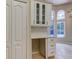 White cabinetry with stylish hardware and glass-front upper cabinets offer ample storage at 10614 Chambers Dr, Tampa, FL 33626