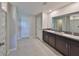 Bathroom featuring a double sink vanity with dark wood cabinets and granite countertop at 11323 Misty Moss Dr, Wimauma, FL 33598