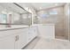 Elegant bathroom features a double sink vanity, large mirror, and a separate tiled shower with glass enclosure at 11885 Richmond Trl, Parrish, FL 34219