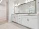 Spacious bathroom with double vanity, large mirror, and walk-in closet, offers ample storage and style at 11885 Richmond Trl, Parrish, FL 34219