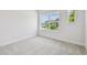 Bright, carpeted bedroom with natural light, neutral walls, and a glimpse of the neighborhood through the window at 11885 Richmond Trl, Parrish, FL 34219