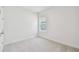 Minimalist bedroom with neutral walls, carpet floors, a single window, and a clean, uncluttered aesthetic at 11885 Richmond Trl, Parrish, FL 34219