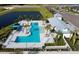 Aerial view of a resort-style pool featuring palm trees, lounge chairs, and a covered seating area at 11885 Richmond Trl, Parrish, FL 34219